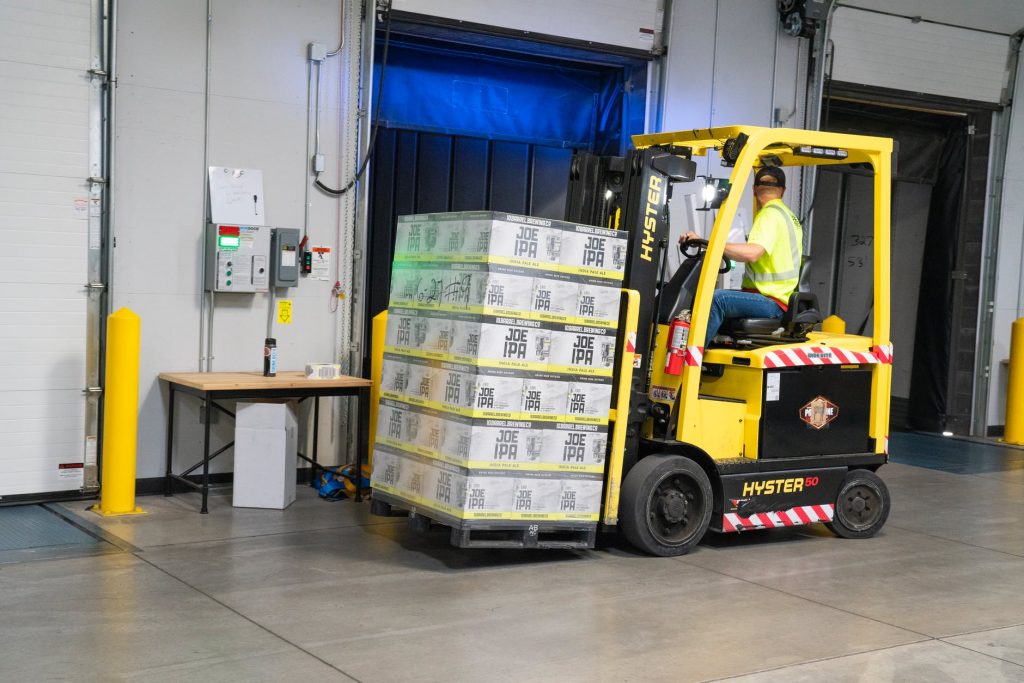 Man operating fork lift while wearing high visibility vest